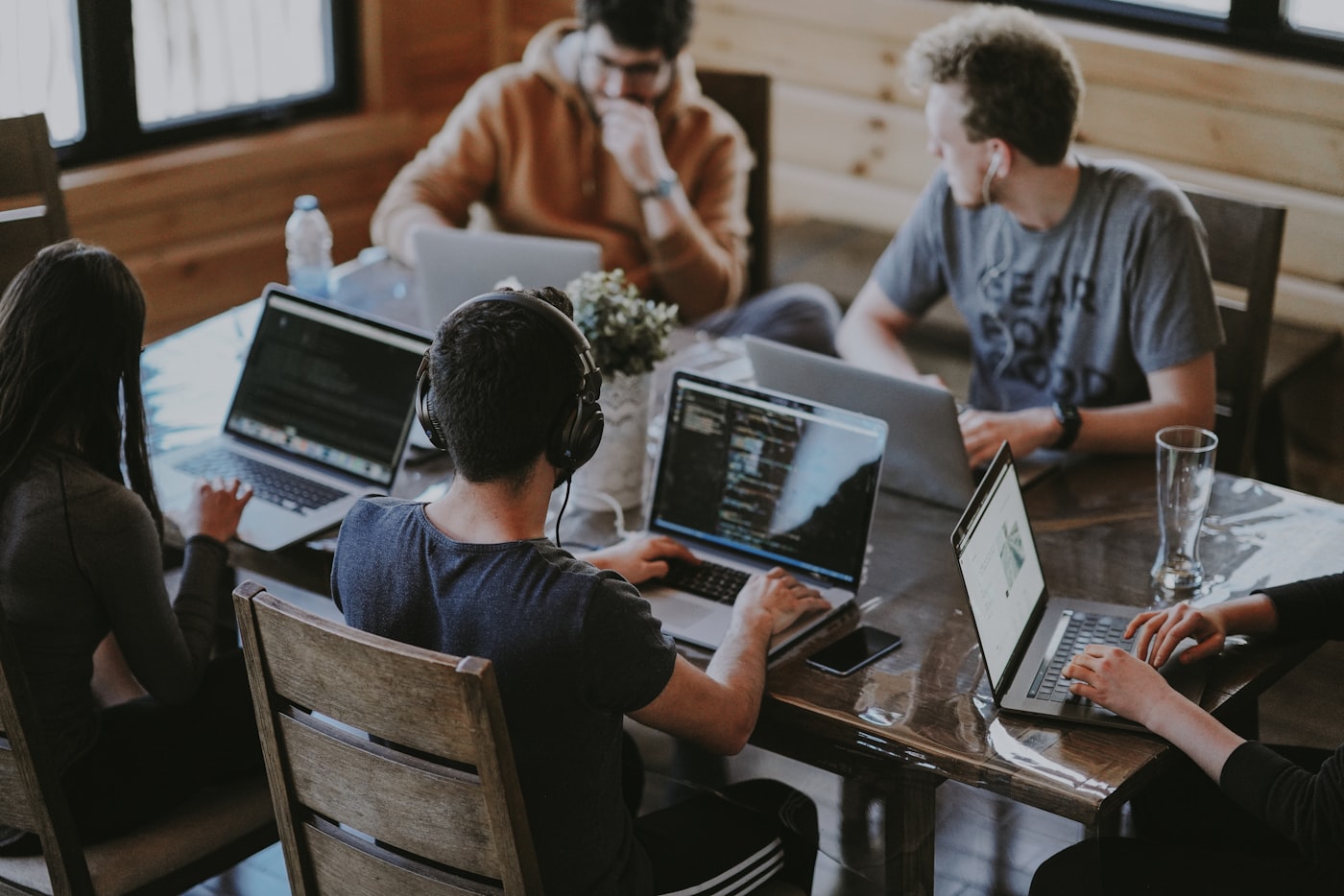 A small team working together at laptops around a shared table.